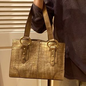 Gold faux reptile bag with gold toned rings and embellishments.